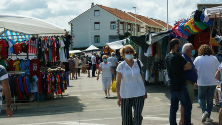 Suances, Cantabria / Spain; 07 14 2020: Several people with masks walking and shopping in the weekly market of Suances, in Cantabria.のeditorial素材
