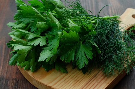 Parsley and dill on cutting boardの写真素材