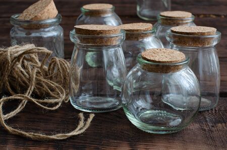 Small glass jars with cork on wooden backgroundの写真素材