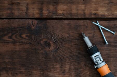 Screwdriver and self-tapping screws on wooden background with copy spaceの写真素材