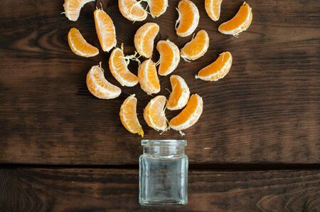 Segments of mandarin and small phial on wooden backgroundの写真素材