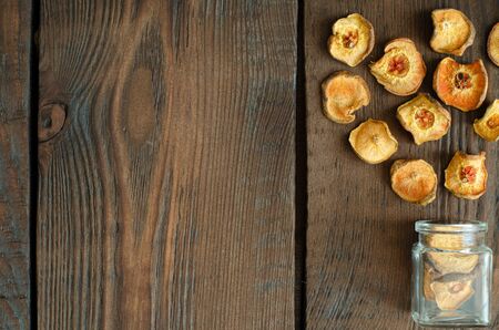 Dried pears from small glass bottle on wooden background. Top view. Copy space.の写真素材