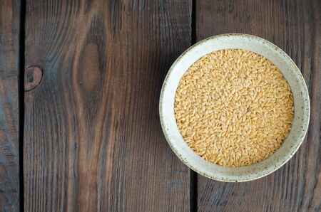 White linseeds in bowl on wooden background with copy space. Top viewの写真素材