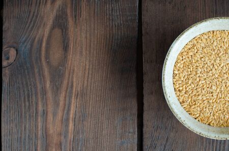 White linseeds in bowl on wooden background with copy space. Top viewの写真素材