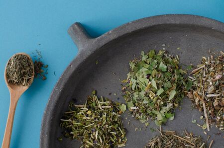 medicinal herbs on concrete dish on blue background. Top view.の写真素材