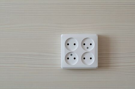 Electric plug socket on light wall backgroundの写真素材