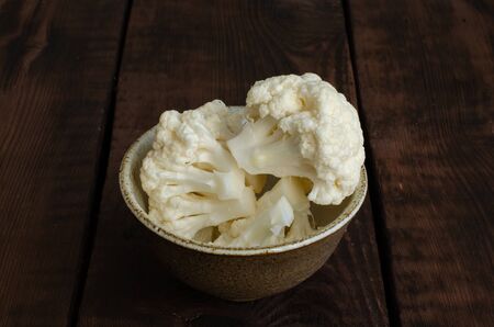 cauliflower in clay bowl on wooden background.の写真素材