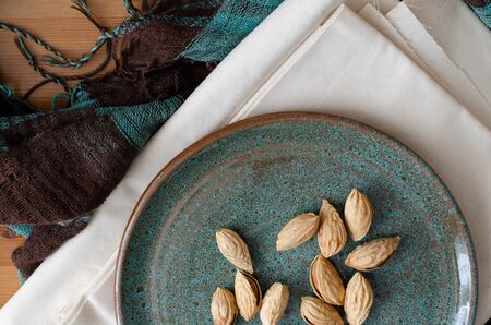 almond in nutshell on clay dish on white linen. Top viewの写真素材