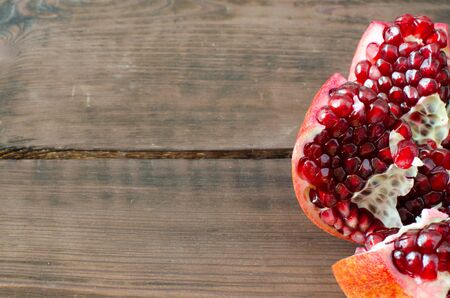 opened granatum on wooden background with copy space.の写真素材