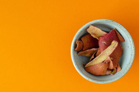 Pomegranate-peel in bowl on orangeの写真素材