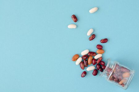 Beans from small phial on blueの写真素材