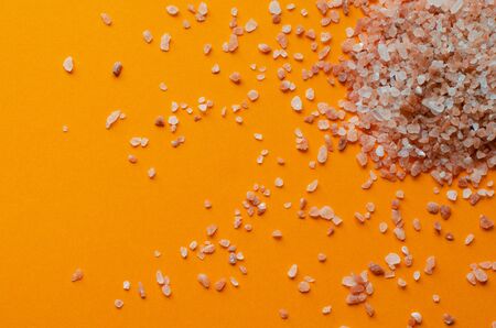 Crystal pink salt pile on orangeの写真素材