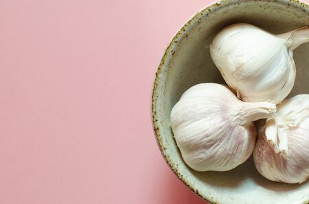 organic garlics in bowl on pink background with copy space. Top viewの写真素材