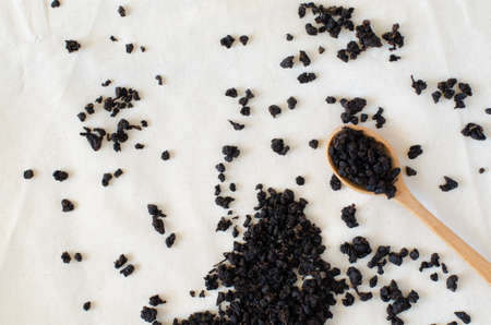 Charcoal roasted high mountain oolong tea from Taiwan in wooden spoon on linen background. Top view.の写真素材