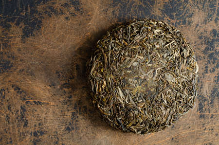 pressed green puer tea on abstract wooden backdrop.の写真素材