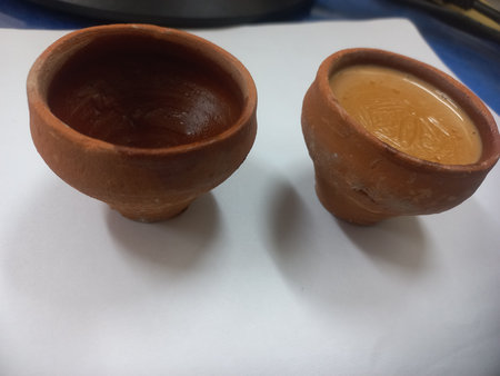 This photo shows a traditional kulhad (clay cup) filled with chai (Indian tea).These clay cups are commonly used to serve hot tea in India,especially at roadside tea shops.Kulhadの写真素材