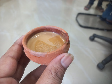 This photo shows a traditional kulhad (clay cup) filled with chai (Indian tea). These clay cups are commonly used to serve hot tea in India, especially at roadside tea shops.の写真素材