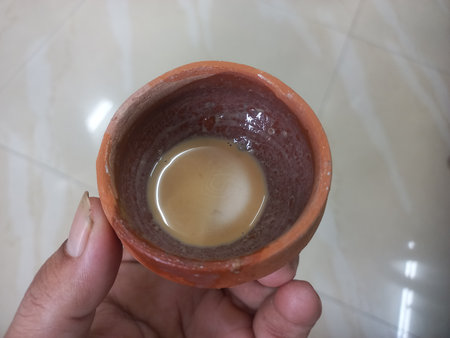 This photo shows a traditional kulhad (clay cup) filled with chai (Indian tea). These clay cups are commonly used to serve hot tea in India, especially at roadside tea shops.の写真素材