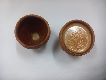 This photo shows a traditional kulhad (clay cup) filled with chai (Indian tea). These clay cups are commonly used to serve hot tea in India, especially at roadside tea shops.の写真素材