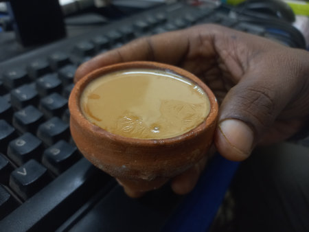 This photo shows a traditional kulhad (clay cup) filled with chai (Indian tea).These clay cups are commonly used to serve hot tea in India,especially at roadside tea shops.Kulhadの写真素材