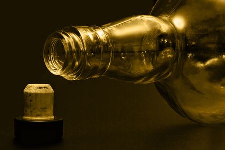 macro: empty bottle isolated on black background and cork gold tintedの写真素材