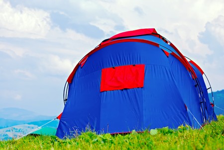 Tourists tent in mountains camp over evening skyの写真素材