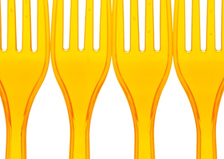 Macro of orange plastic forks over whiteの写真素材