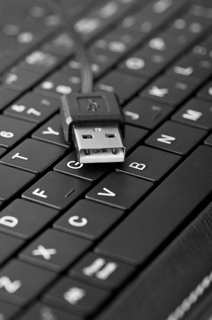 Technology background: Macro of laptop keyboard and usb connection cable. Shallow depth of field,...