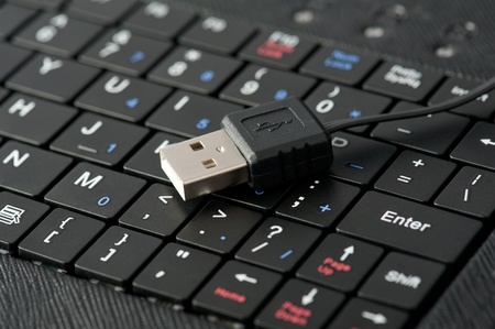 Technology background: Macro of laptop keyboard and usb connection cable. Shallow depth of fieldの写真素材