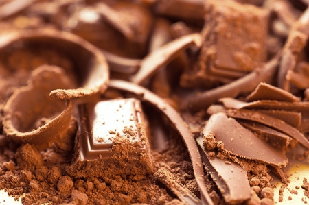 Chocolate background. Bars and strips of chocolate with cocoa powder. Shallow depth of field