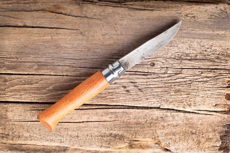 Stainless steel knife on vintage wooden cutting boardの写真素材