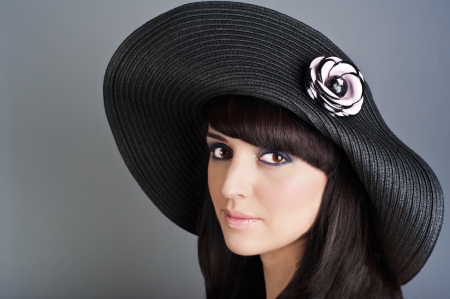 Portrait of young beautiful woman in modern hat with flower decorの写真素材