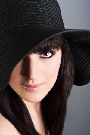 Portrait of young beautiful woman with professional evening style make up in vintage hatの写真素材