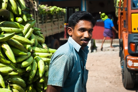 ALAPPUZHA INDIA - February 23: Indian man with a cargo of bananas going to market place. India, Kerala, Alappuzha. February 23, 2013のeditorial素材