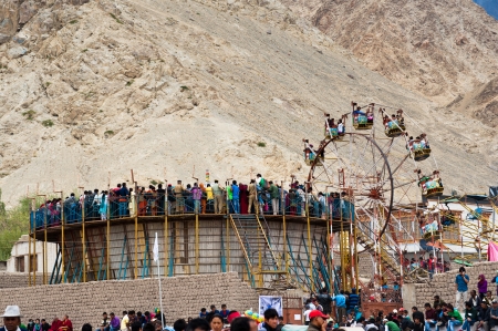LEH, INDIA - SEPTEMBER 08, 2012: Unidentified Tibetan people at fairground enjoying ferris wheel. Folk festival performance at Annual Festival of Ladakh Heritage in Leh, India. September 08, 2012のeditorial素材