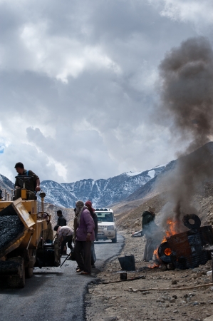 KHARDUNG LA PASS, INDIA - SEPTEMBER 12: Indian people working at road construction at Khardung La pass. The one main road at Himalaya mountains, altitude 5600 m. India, Ladakh, September 12, 2012のeditorial素材