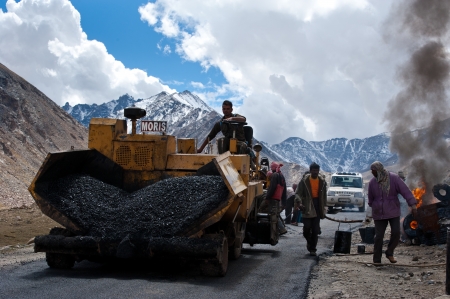 KHARDUNG LA PASS, INDIA - SEPTEMBER 12: Indian people working at road construction at Khardung La pass. The one main road at Himalaya mountains, altitude 5600 m. India, Ladakh, September 12, 2012のeditorial素材