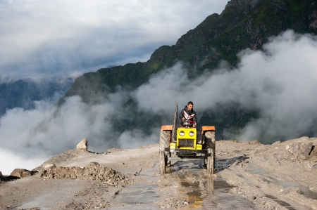 ROHTANG PASS, INDIA - SEPTEMBER 05: Unidentified Indian man driving tractor, working at road...