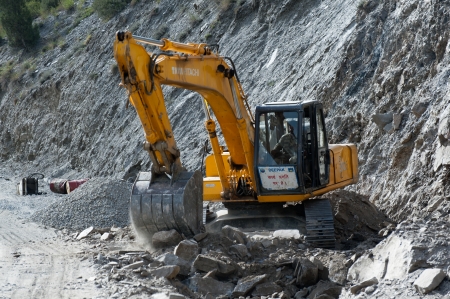 KEYLONG, INDIA - SEPTEMBER 06  Unidentified Indian man excavator operator,  works at road construction near Keylong village, Manali-Leh  highway  India, Himachal Pradesh, September 06, 2012のeditorial素材