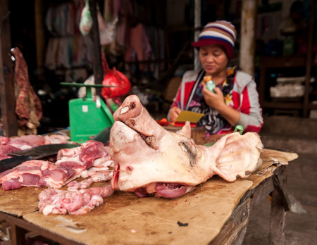 SIEM REAP, CAMBODIA - DEC 22, 2013: Unidentified Khmer woman selling meat at traditional food marketplace on Dec 22, 2013 in Siem Reap, Cambodia. Street food markets is popular tradition in asiaのeditorial素材