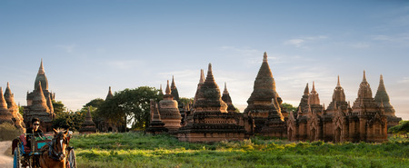 BAGAN, MYANMAR - JAN 15: Unidentified Myanmar man the horse carriage driver passes by ancient ruins of old Buddhist temples at Bagan Kingdom, Myanmar (Burma) on Jan 15, 2014のeditorial素材