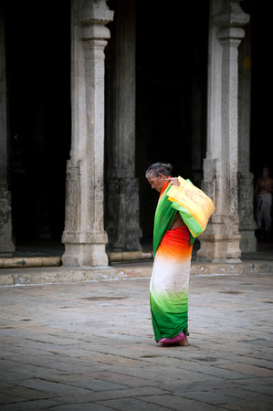 MADURAI, INDIA - FEBR 16: Indian woman in colorful sari carrying bale with offerings for  religious ritual at Meenakshi Temple holy place for hindu people on Febr 16, 2013. India, Madurai, Tamil Naduのeditorial素材