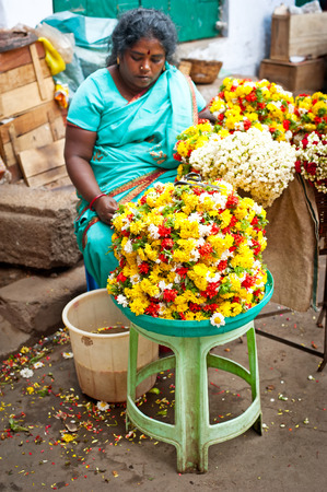 TRICHY, INDIA - FEBR 14: Indian women selling colorful flower garland at street market place for religion ceremony or fashion decoration on Febr 14, 2013. India, Tamil Nadu, Thanjavur (Trichy)のeditorial素材