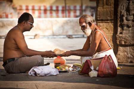 MADURAI, INDIA - FEBR 16: Hindu Brahmin with religious attributes providing ceremony and blessing pilgrim at holy place for hindu people Meenakshi Temple on Febr 16, 2013. India, Madurai, Tamil Naduのeditorial素材