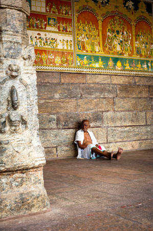 MADURAI, INDIA - FEBR 16: indian man pilgrim resting inside ancient colonnade of Meenakshi Temple one of the most holy place for hindu people on Febr 16, 2013. India, Madurai, Tamil Naduのeditorial素材
