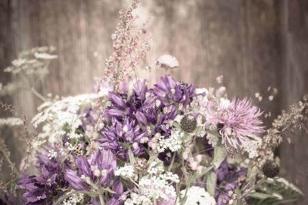 Beautiful tender bouquet of summer meadow flowers on wooden background. Floral composition in rural vintage styleの写真素材