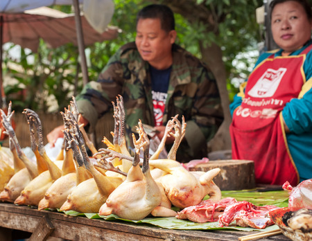 LUANG PRABANG, LAOS - DEC 8: Unidentified people selling meat at traditional food marketplace on Dec 8, 2013 in Luang Prabang, Laosのeditorial素材