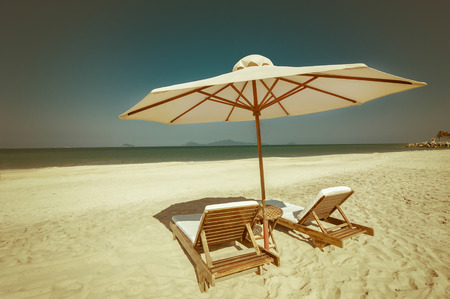 Amazing tropical beach with chairs and umbrella on sand. Travel nature landscape in vintage style. Vietnamの写真素材