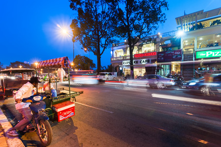 PHNOM PENH, CAMBODIA - DEC 29, 2013: Vendor selling food at evening asian city. Scene of night life at most popular tourist street near Royal Palace in capital city Phnom Penh, Cambodiaのeditorial素材