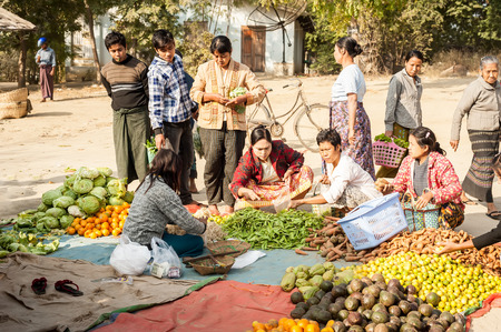 BAGAN, MYANMAR - JANUARY 16, 2014: Burmese people shopping spices, greengrocery and local goods at traditional asian marketplace. Burma travel destinationsのeditorial素材